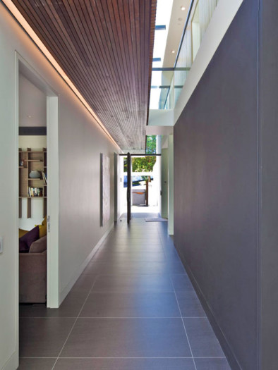 Крупный матовый керамогранит в узком коридоре. Раскладка от центра и две равномерных подрезки по краям.