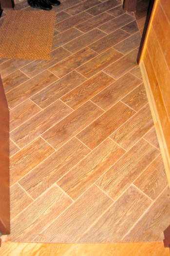 Прямоугольная плитка под паркет уложена по диагонали.